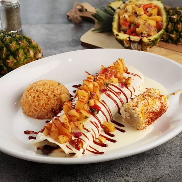 El Patron Mexican Grill's burrito with pineapple salsa, rice, and elote, with pineapple in background.