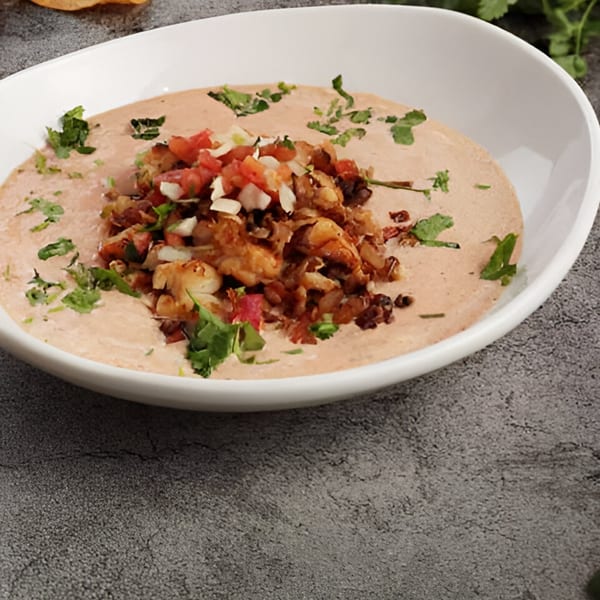 El Patron Mexican Grill's shrimp ceviche in a white bowl, garnished with cilantro and pico de gallo.