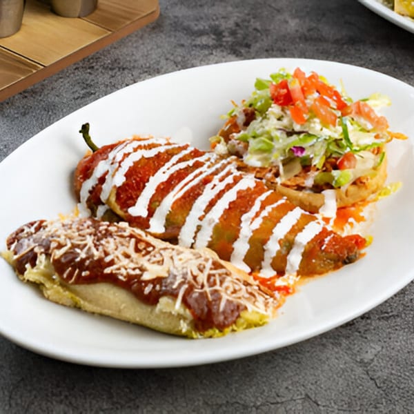 El Patron Mexican Grill's chile relleno, tamale, and tostada with toppings on a white plate.